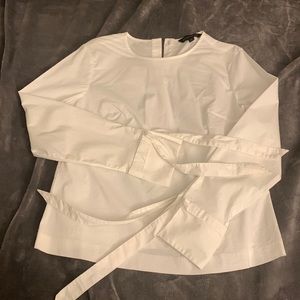 Crisp white long sleeve top with back buttons and tie cuffs